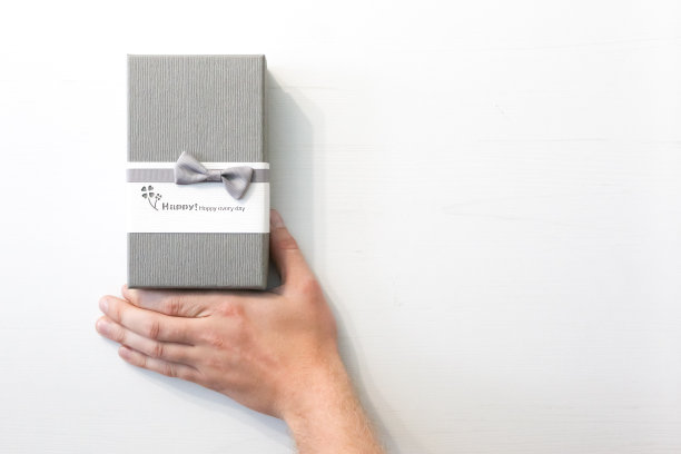礼盒在一个男人的手里，背景是白色的。现在图片下载