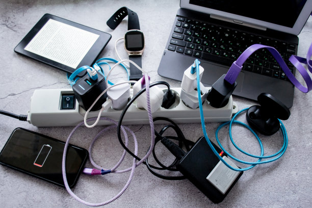 俯视图许多小玩意-智能手机，无线耳机，笔记本电脑，智能手表，相机电池和电子书是在一个电源条充电图片下载