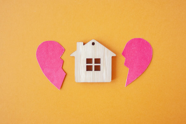 离婚，财产分割，贫穷和无钱的概念。带着破碎的心的木头房子在明亮的橙色背景上。抵押贷款、租赁、房地产经纪人图片下载