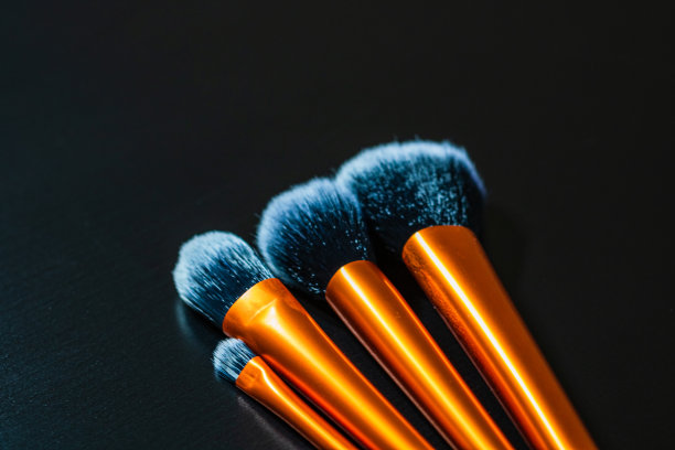 化妆刷靠近孤立在黑色的桌子上。图片下载
