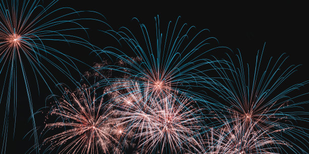 真正五颜六色的烟花在夜空中，五颜六色的烟花在黑色的背景上图片下载