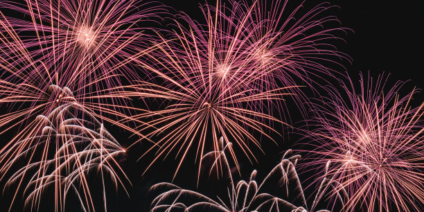 真正五颜六色的烟花在夜空中，五颜六色的烟花在黑色的背景上图片下载