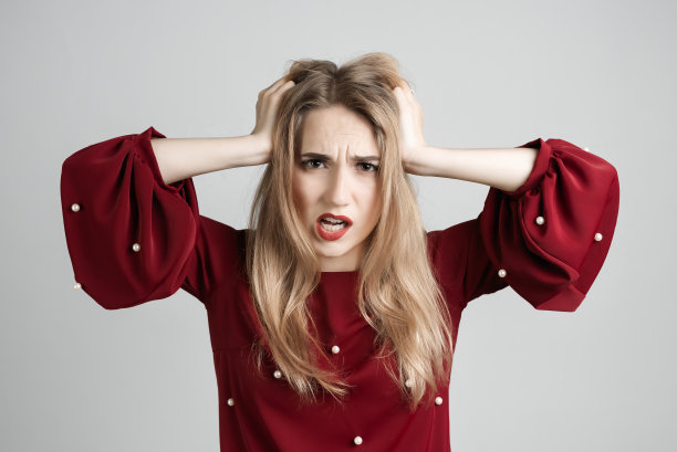 有着金色长发的女孩双手抱头，表现出问题、惊讶、恐惧、恐惧症的概念图片下载