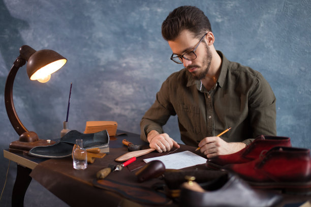 工匠正在写靴子的草图图片下载