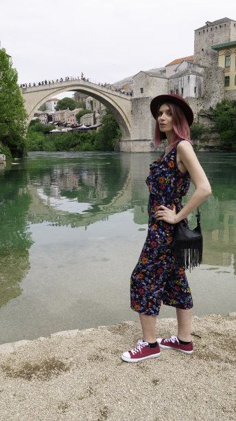 波斯尼亚和黑塞哥维那，莫斯塔尔，一名年轻女性游客在涅雷特瓦河和老桥前。图片下载