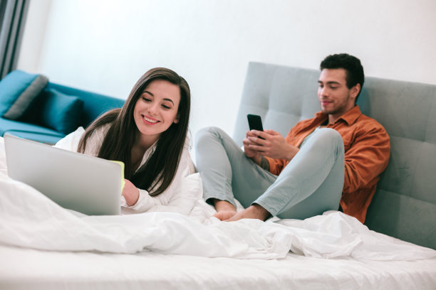 欢乐的夫妇在家里放松与现代的小工具图片下载