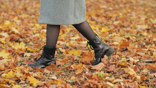一个穿着温暖靴子的女孩走过落叶图片下载