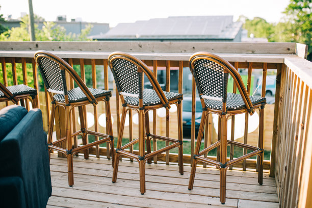 在后院的木甲板上排列着几把高椅子。图片下载
