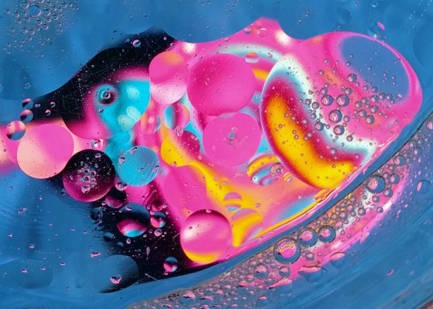 不同大小的圆形水滴的明亮背景。油滴在水中，颜色反射。对空间的抽象模仿。粉色、黄色和蓝色元素。圆圈和轮子。Macroabstraction图片下载