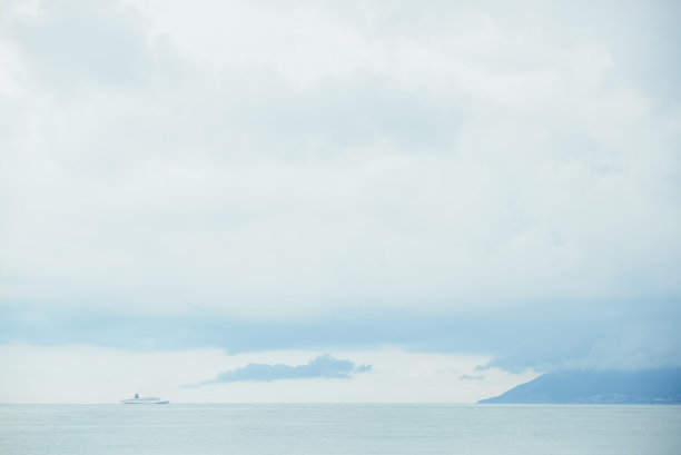 海上游船以壮观的天空、大海和山景为背景图片下载