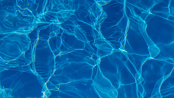 池子里的水是蓝色的，被阳光穿透了。有选择性的重点。健康的生活方式。度假的孩子。图片下载