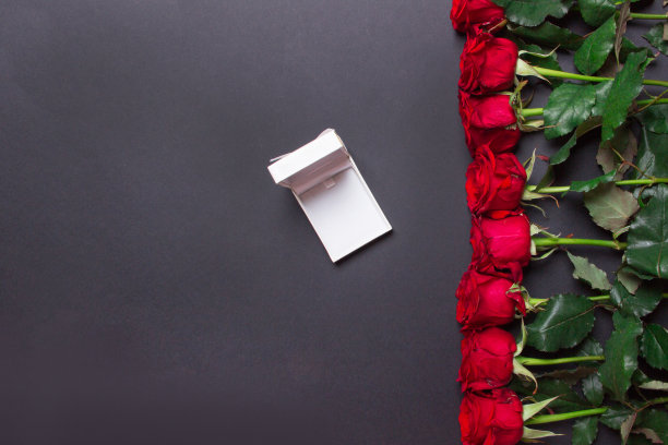 红色玫瑰线和打开礼盒在黑色纸张背景，与拷贝空间图片下载
