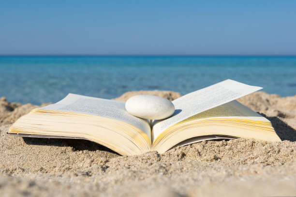 在沙滩上翻开书，仔细看图片下载