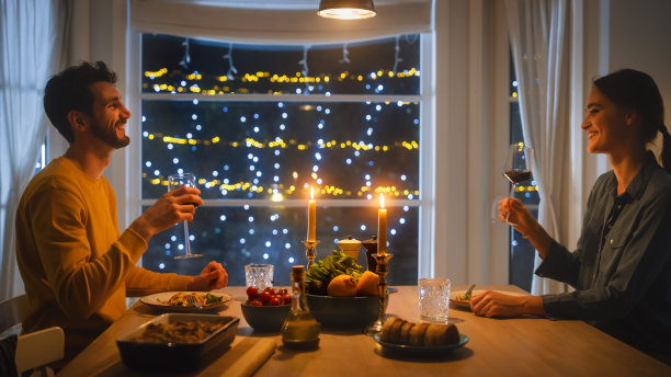 幸福的情侣吃浪漫的晚餐，在厨房吃美味的饭菜，庆祝，交谈。美丽可爱的丈夫和妻子有浪漫的时间图片下载
