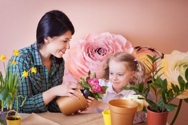 可爱的小女孩帮助妈妈照料植物。图片下载