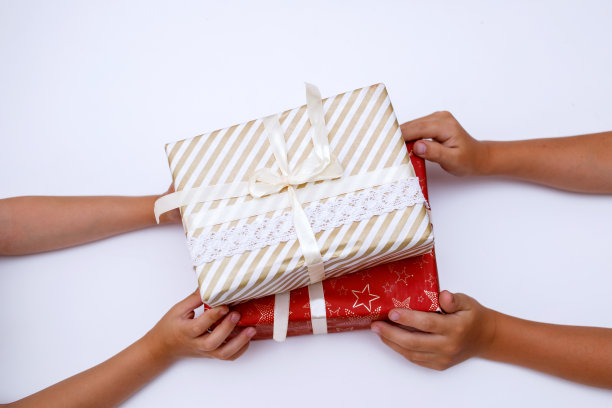 双手牵着两边的两个礼物，红色的包装。图片下载