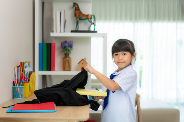 亚洲可爱的小学女生收拾书包，准备开学第一天。早上学校的日常生活为上学做准备。图片下载