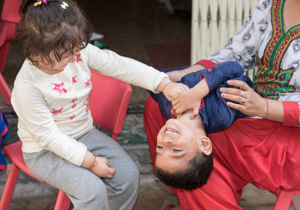 孩子们在家里玩得很开心，挠痒痒，咯咯笑。图片下载