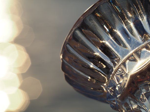 一个玻璃烛台支架的特写照片与日落的天空在背景图片下载