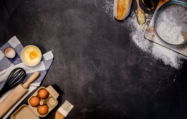 用面粉自制烘焙原料，在深色背景下制作蛋糕。俯视图和平放照片与文本复制空间。图片下载