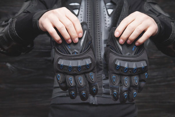 手持防护手套的摩托车手。骑摩托车的人装图片下载