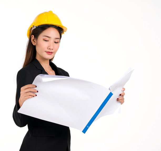 一位身穿黑色西装、头戴黄色建筑帽的年轻女商人正在享受一个进步的房地产计划。工程业主正在检查施工图图片下载