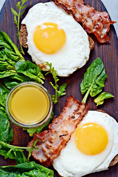 早餐煎蛋配培根、新鲜菠菜、芝麻菜和橙汁。图片下载