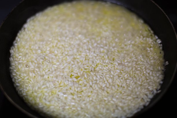 用铸铁平底锅煮意大利调味饭。意大利菜。图片下载