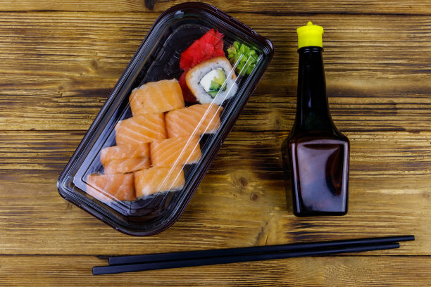 寿司卷费城在塑料盒在木桌上。前视图。装在塑料容器内的寿司供外卖或运送图片下载