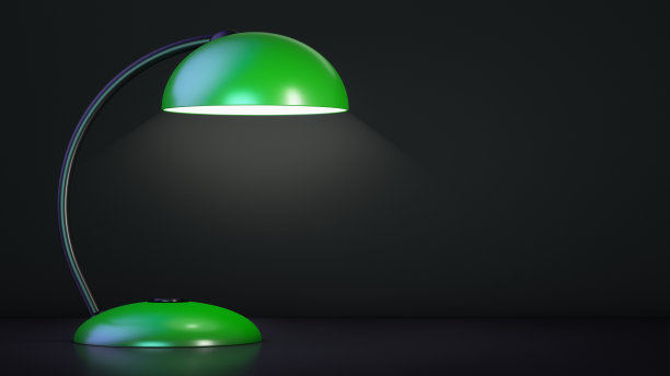 绿色的台灯是亮着的。黑暗的背景。图片下载