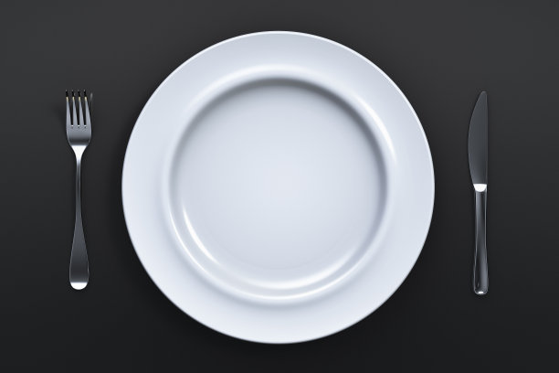黑色的桌子上放着空的陶瓷盘子和刀叉。从以上观点。图片下载