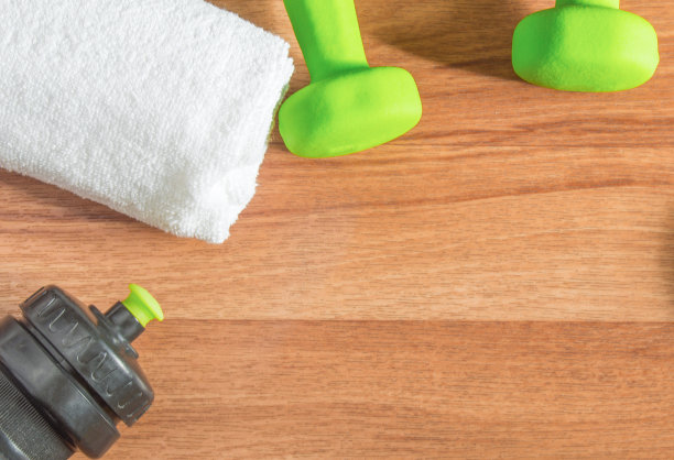 健身概念与哑铃，水瓶，卷尺，毛巾在木制背景图片下载