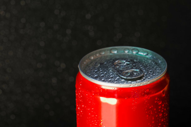 红色铝罐在水滴在黑色的背景图片下载