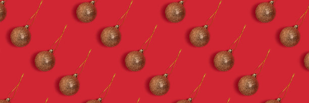 旗帜与金色闪闪发光的圣诞球图案在一个红色的背景。图片下载