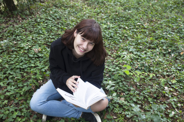 女孩坐在森林里看书图片下载