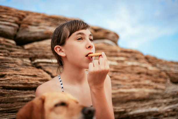 在海滩上吃饼干的女孩图片下载