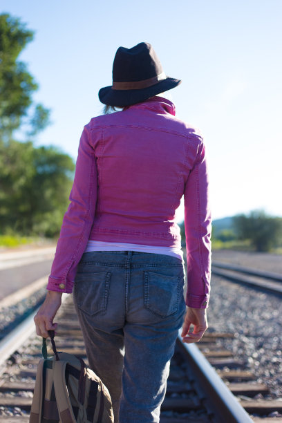 粉红色的女人走在铁轨上图片下载
