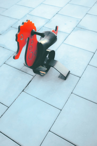 操场上蓝色背景下的红色儿童玩具。图片下载