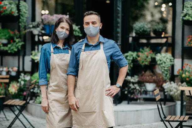 家庭创业和花卉设计。男孩和女孩站在花店的背景图片下载