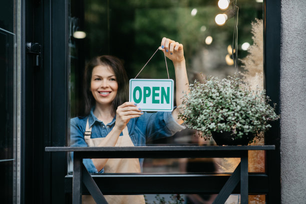 快乐女孩开花店，翻开铭牌上写着“开”图片下载