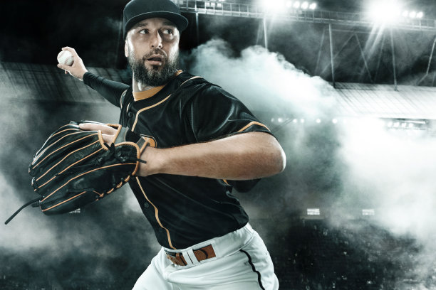 在大舞台上带球的职业棒球运动员。在运动场上的球员。图片下载