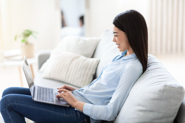 远程办公。微笑的亚洲自由职业女性在家里用笔记本电脑工作图片下载