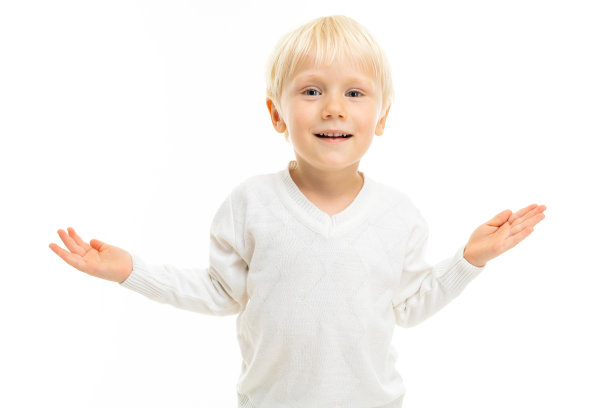 小男孩留着金色的短发，蓝色的眼睛，外表可爱，穿着白色的夹克，浅蓝色的裤子，站在那里微笑着图片下载