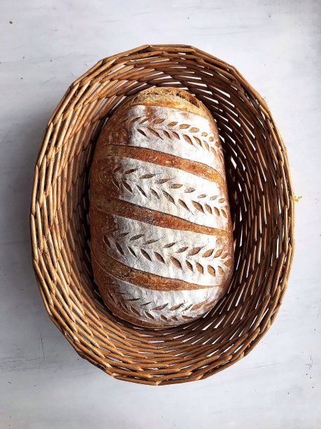 白桌子上的篮子里装着酸面包图片下载