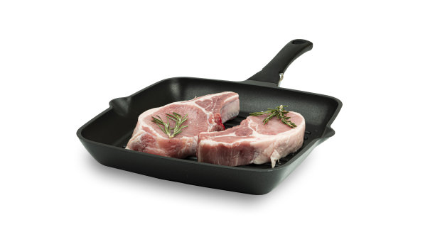 生牛排和迷迭香在烤盘上，白色背景图片下载