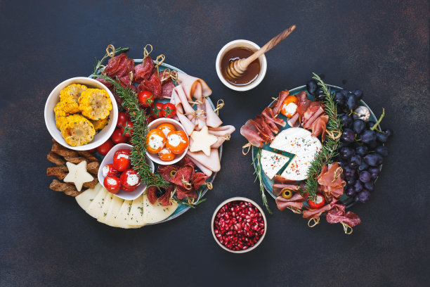 一盘混合小吃。开胃拼盘与奶酪，意大利腊肠，坚果橄榄，水果，蔬菜和面包棒。俯视图，空白区域图片下载