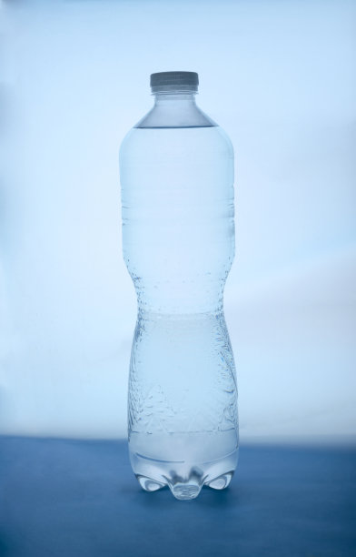 蓝色背景上的塑料瓶水的特写图片下载