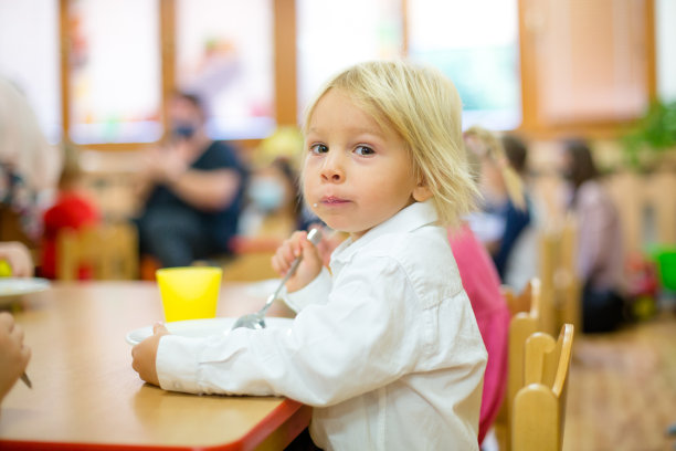 蹒跚学步的孩子，在幼儿园吃早餐图片下载
