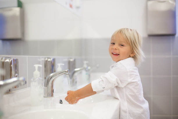 学龄前儿童，金发男孩，在幼儿园的卫生间洗手图片下载