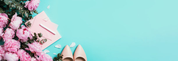 女性的工作空间，笔记本，鞋子，粉红色的牡丹，桉树花在蓝色的背景。俯视图，复制空间。博客，女性化的商业理念。平的。生日，周年聚会，妇女节图片下载
